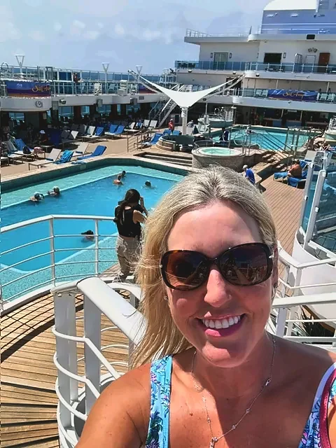 Jennifer Gregg of Travel with Jennifer on a cruise ship pool deck